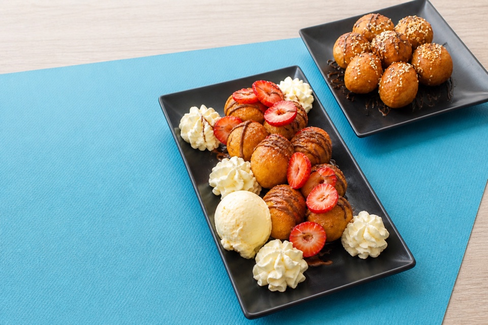 Loukoumades served with strawberries, chocolate sauce, cream and ice cream
